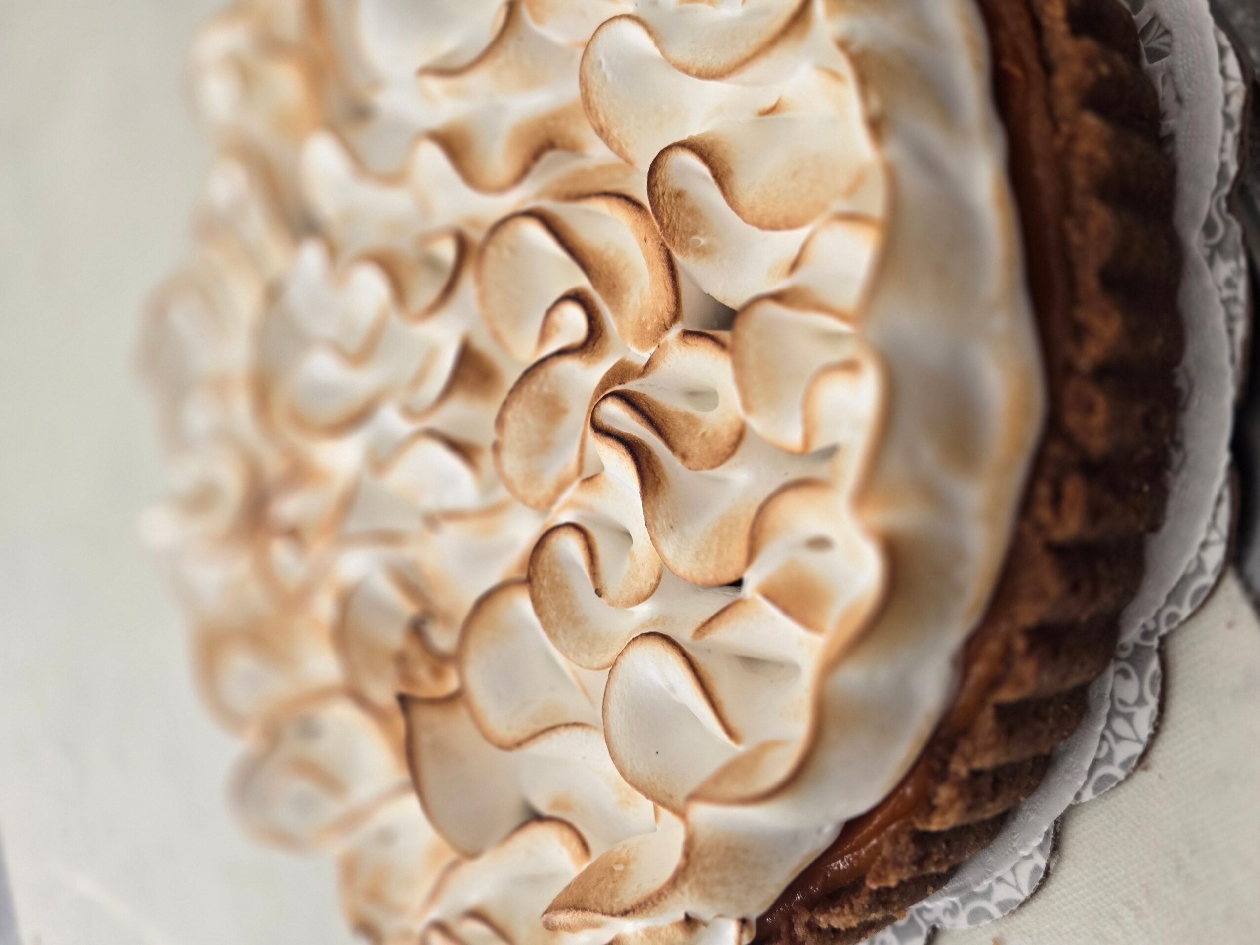 Close-up of a decorated cake with cream and chocolate layers, showing detailed piping and textures.