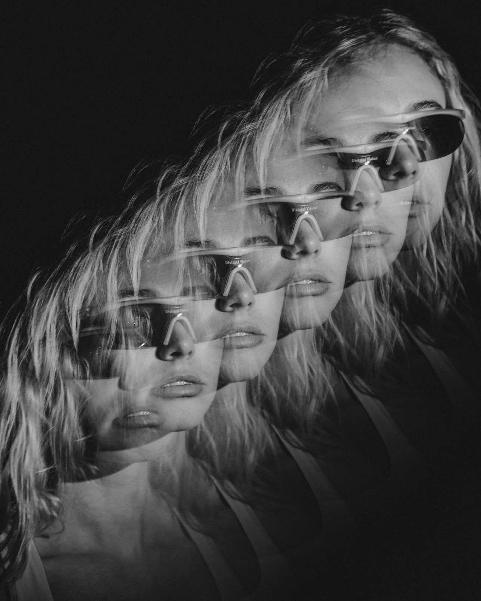 Multiple overlapping images of a woman with sunglasses and wavy hair, in black and white.