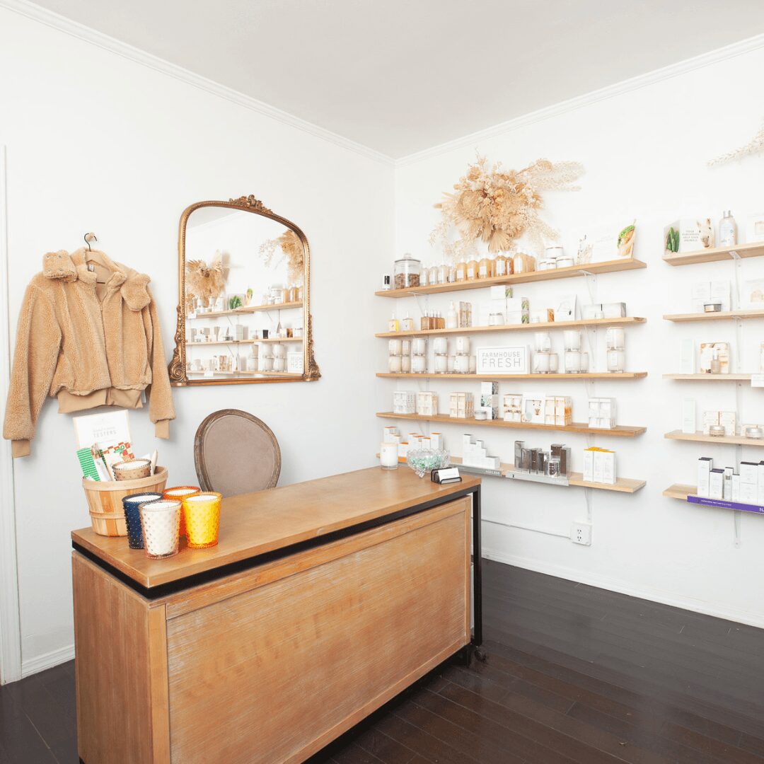 Interior of a shop with a wooden counter, shelves with products, and a mirror on the wall.