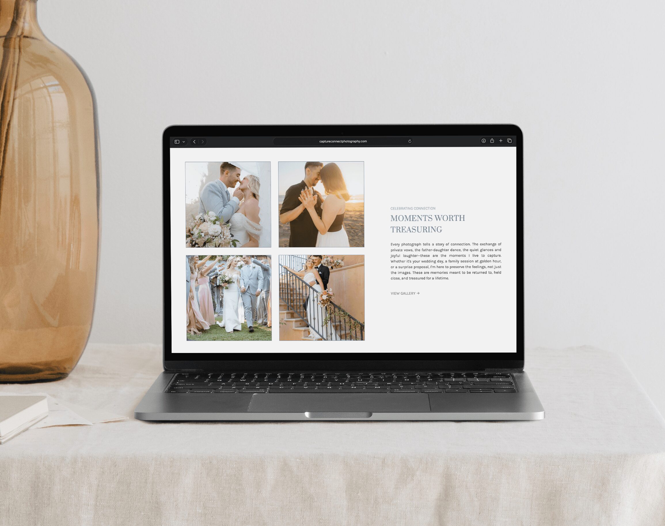 Laptop on a table displaying a webpage with four photos and text, against a plain background.