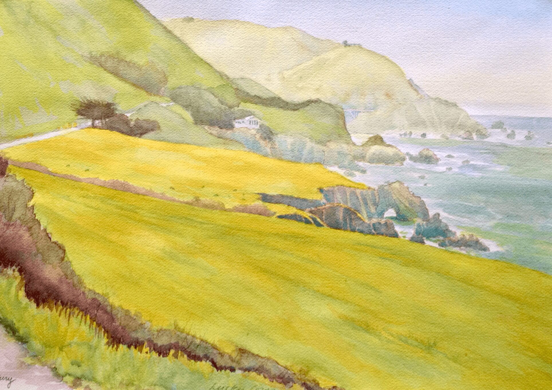 Watercolor landscape of rolling green hills, yellow fields, and distant coastline with cliffs and ocean, under a light sky.