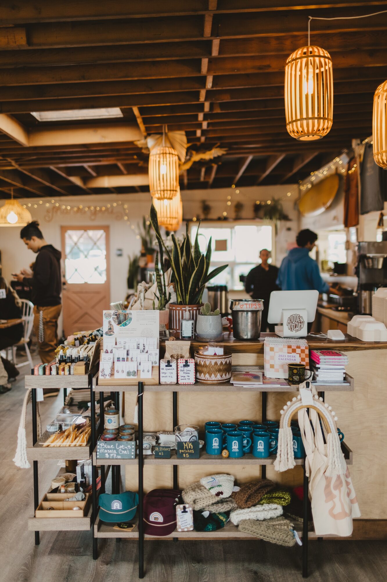 Interior of a shop with hanging lanterns, shelves with various items, and people shopping.