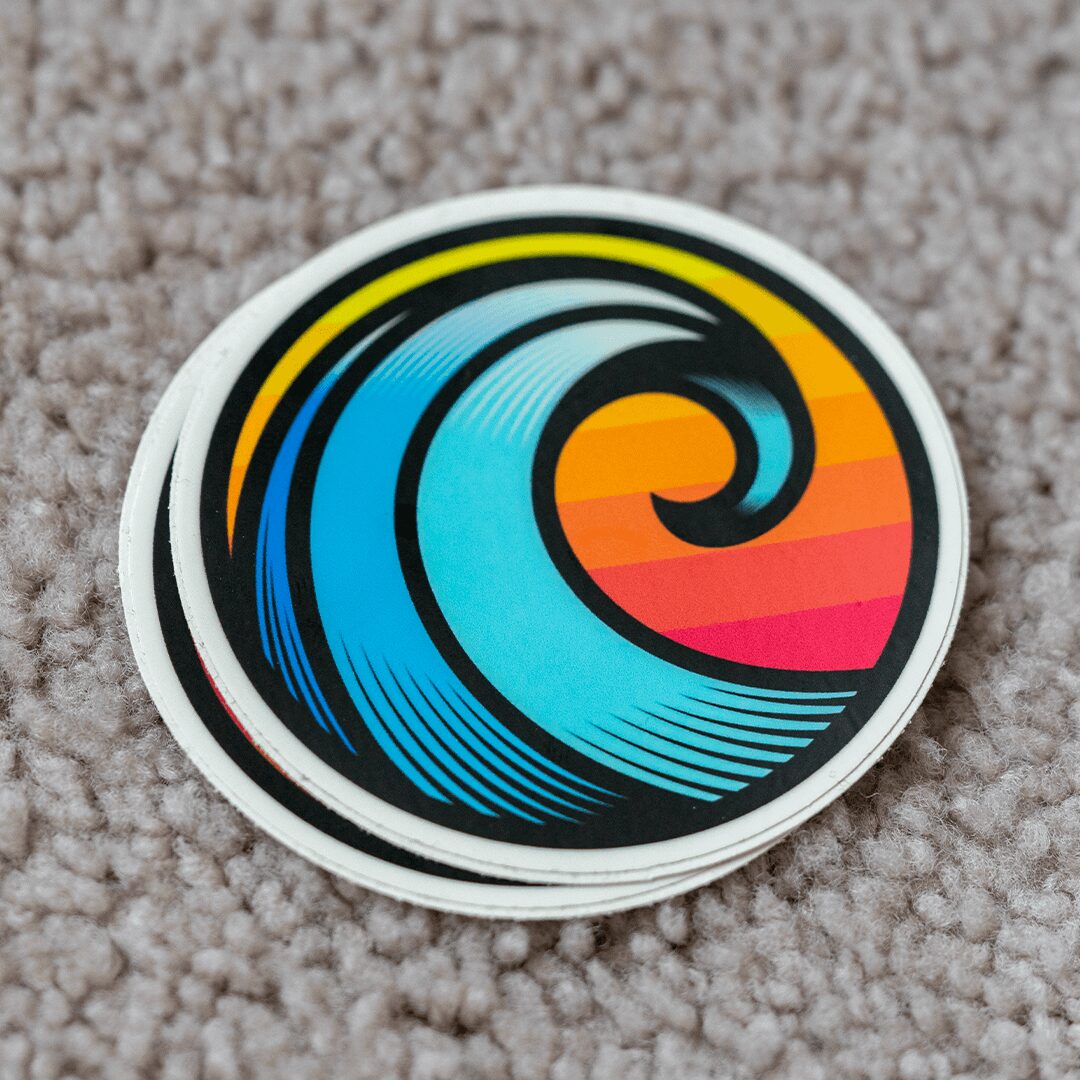 Colorful wave design with blue, yellow, orange, and red stripes on a white background, placed on a textured surface.