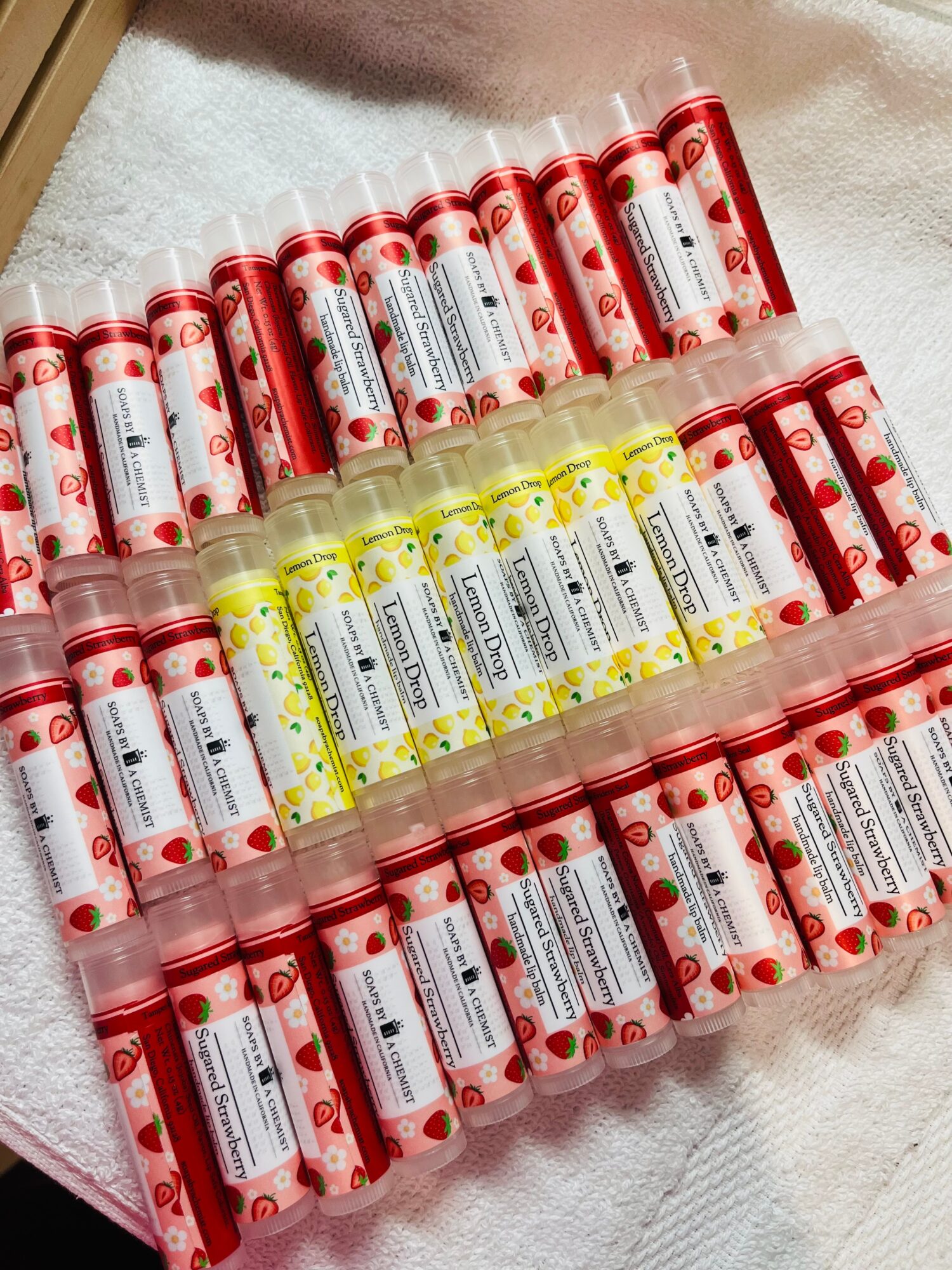 Multiple tubes of red and yellow paint arranged on a white surface, with labels visible on each tube.