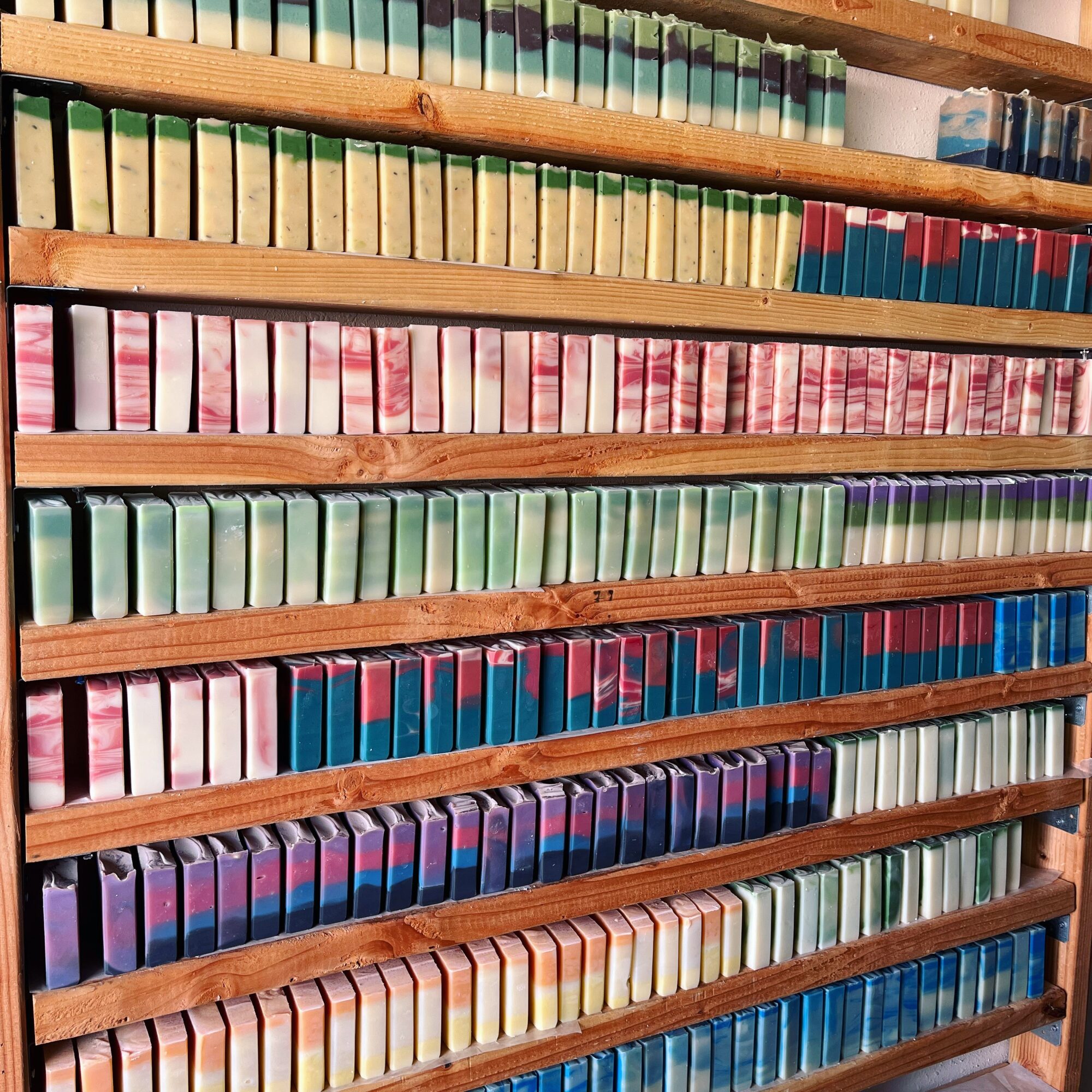 Bookshelves filled with colorful books arranged in rows on wooden shelves.