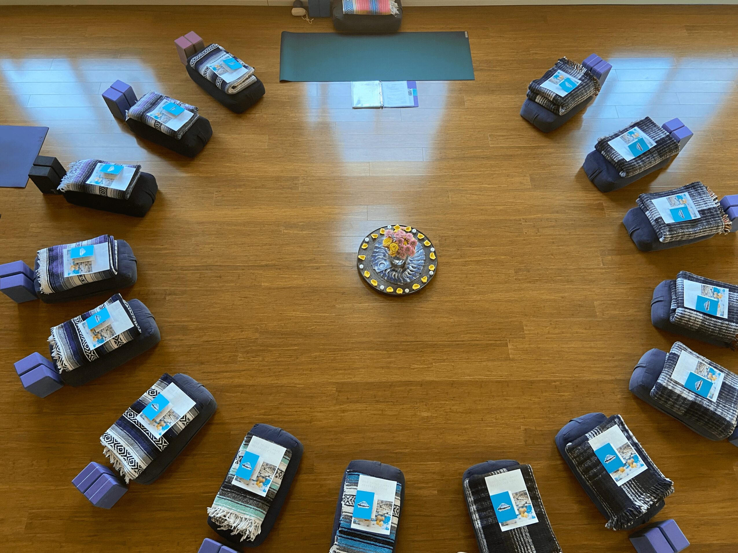 A circular arrangement of bottles on a wooden floor with a small decorative object in the center.