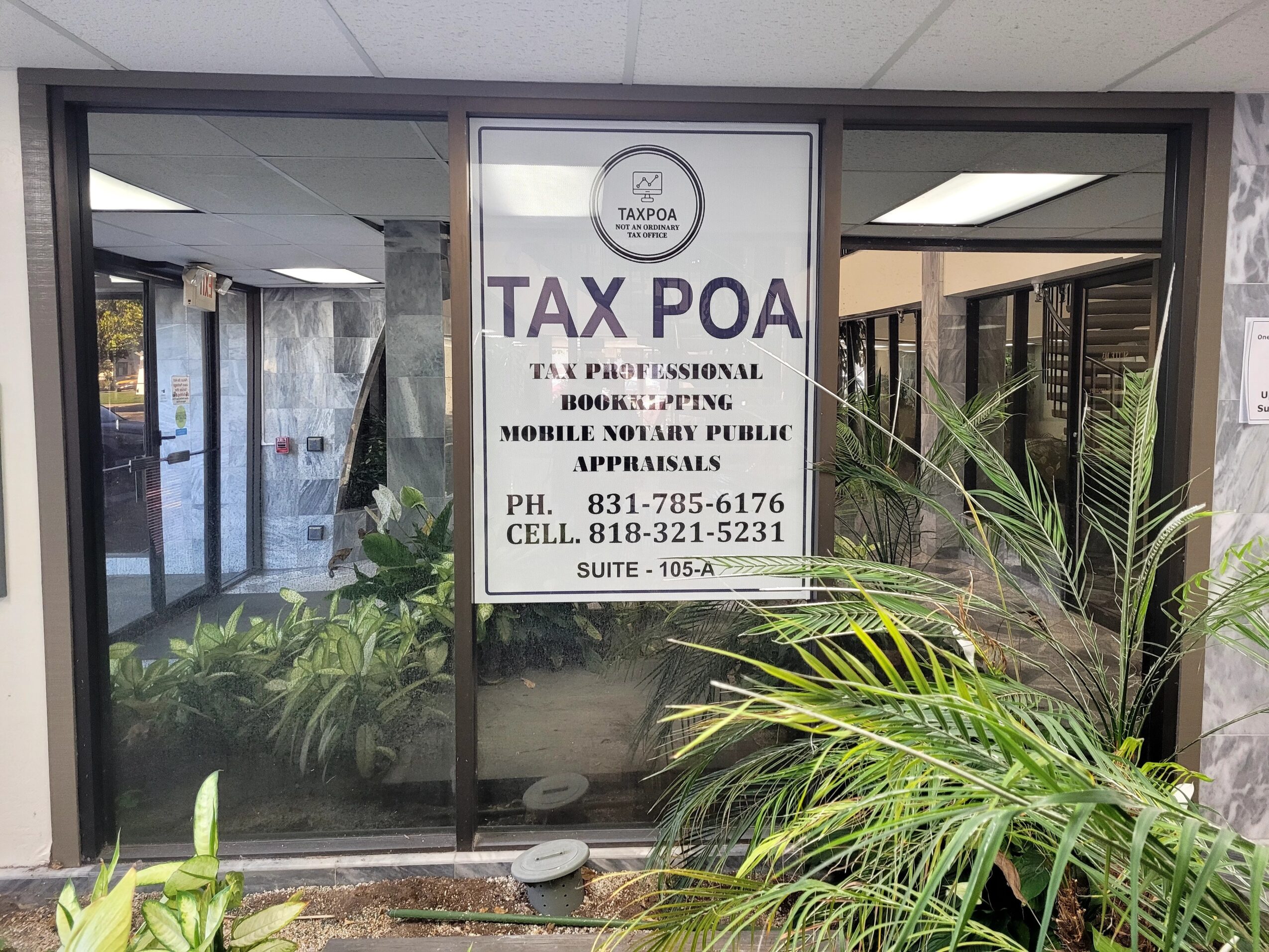 Sign advertising tax preparation services in a window, with plants and office interior visible behind glass.