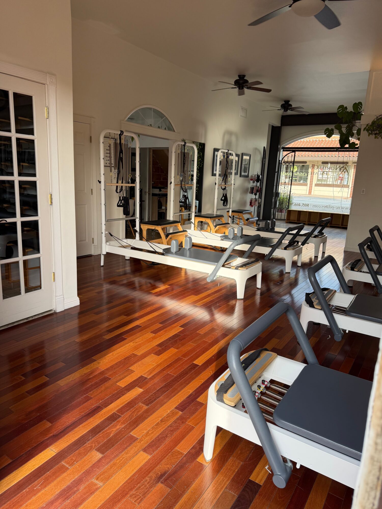Room with wooden floor, exercise equipment, and a window with a view outside.