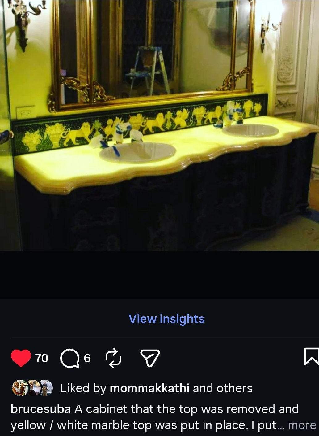Bathroom with three sinks, a large mirror, and a cabinet removed from the top, revealing a yellow wall with floral wallpaper.