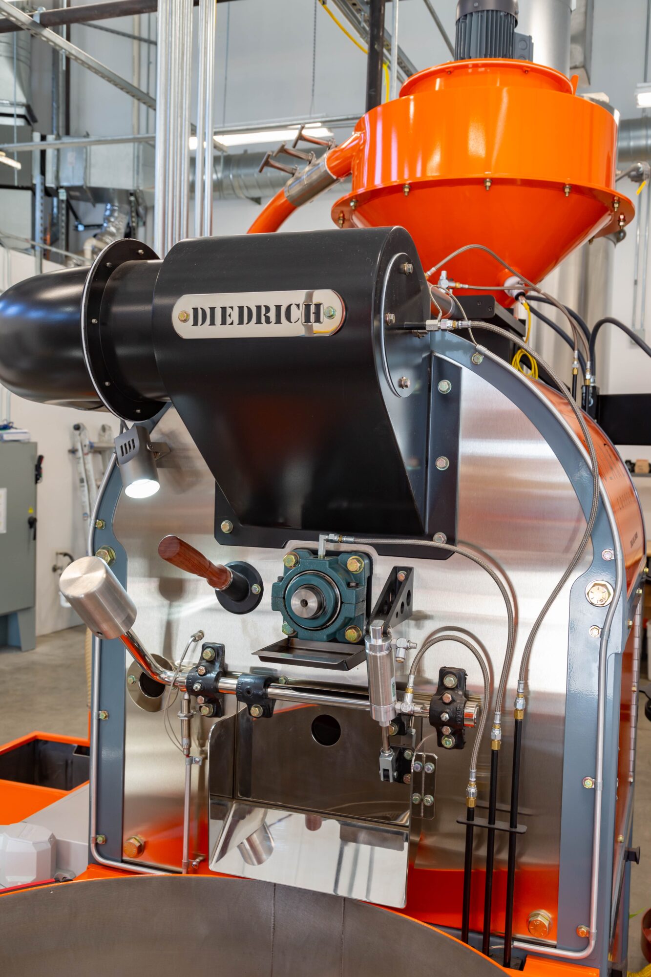 Industrial machine with black and orange components, labeled Diedrich, in a factory setting.