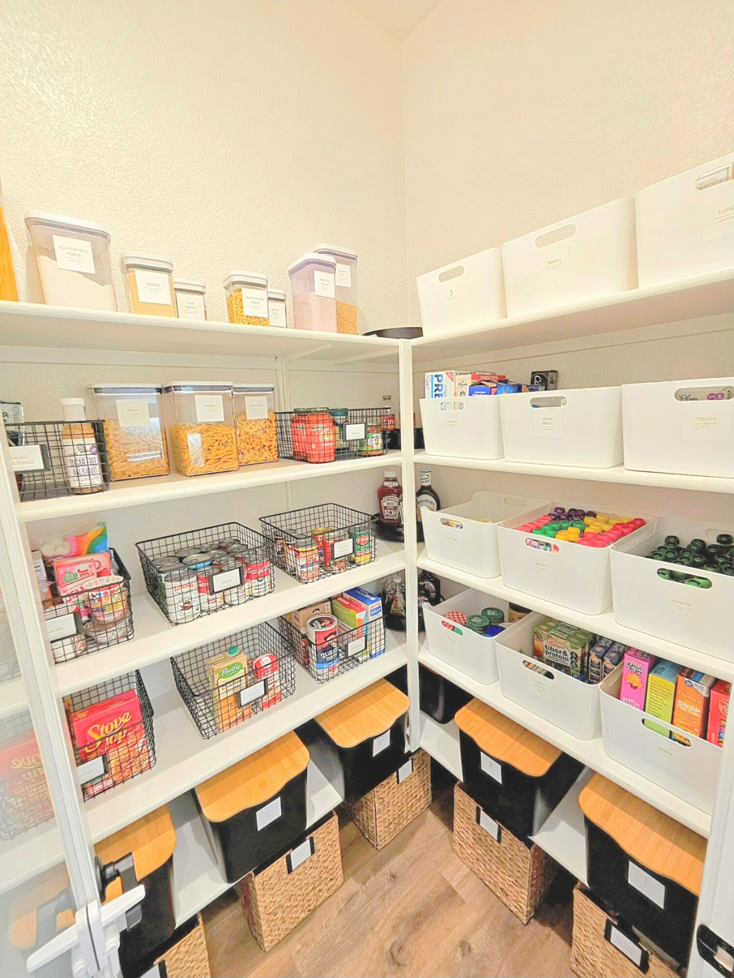 Shelves filled with organized boxes and containers, some with colorful items, in a storage room. Two stools are below the shelves.