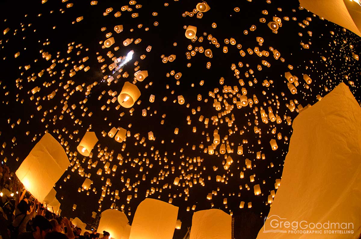 Numerous floating lanterns illuminate the night sky during a celebration or festival.
