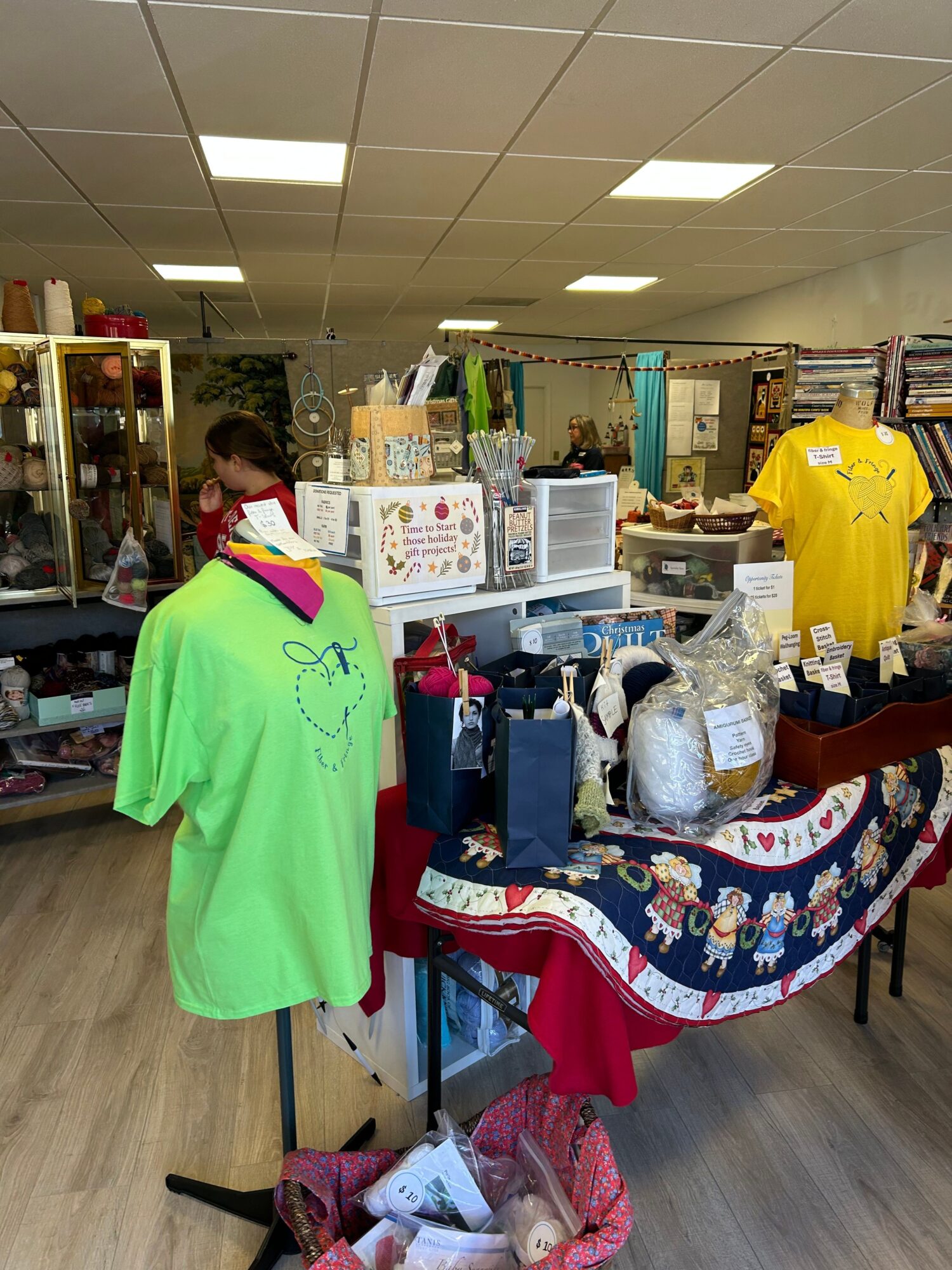 Person in bright green shirt browsing items at a table in a store, with various products and shelves around.