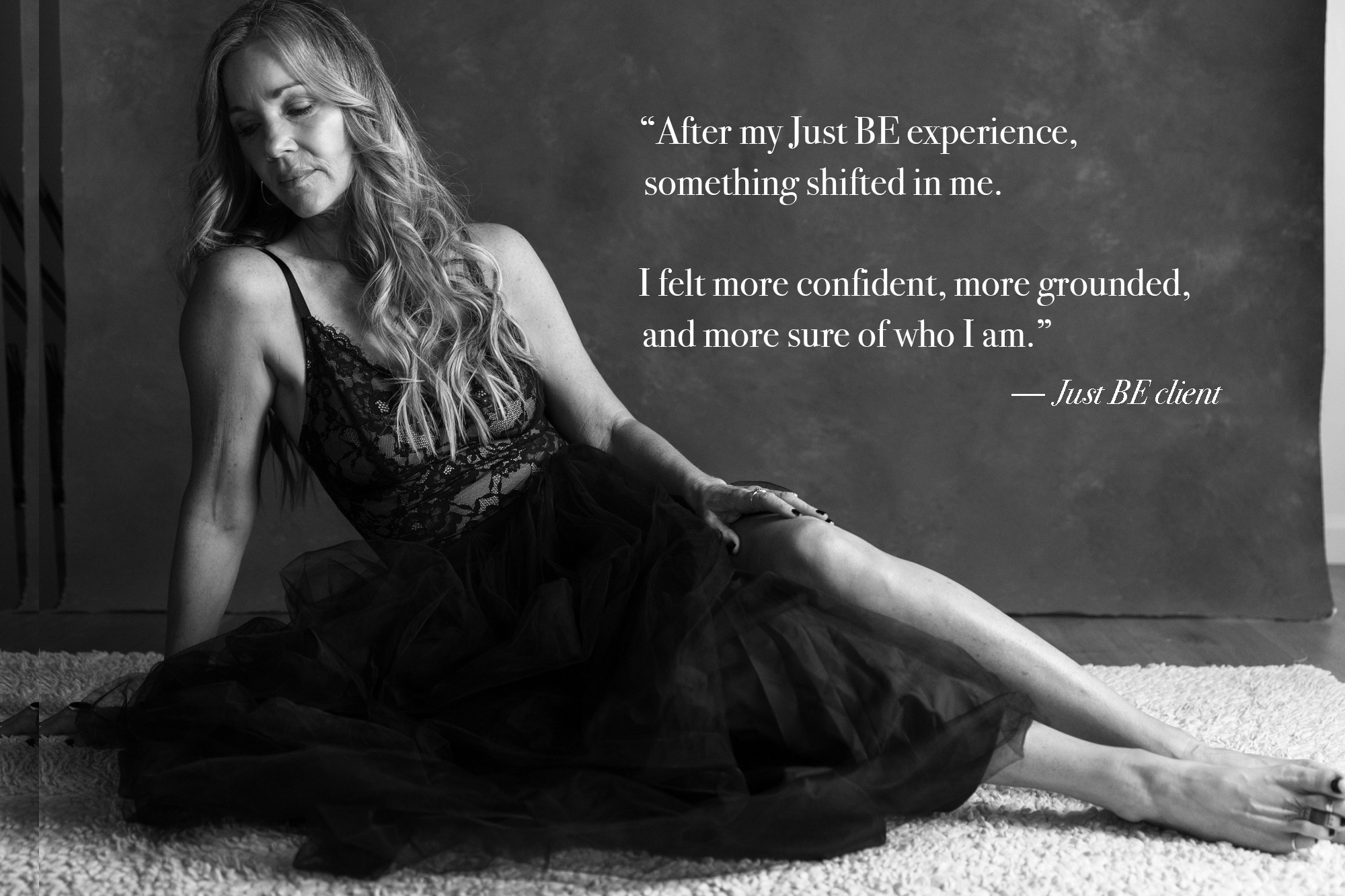 Woman sitting on the floor with long hair, wearing a dress, against a wall with quote text on the right side.