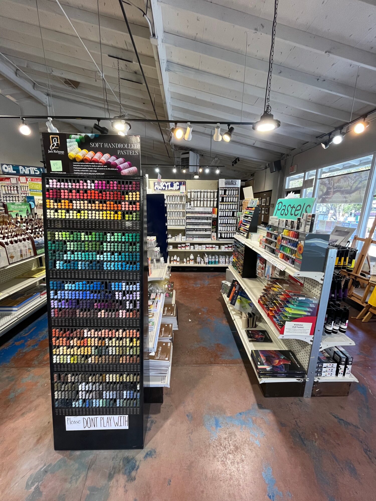 Colorful display of art supplies and stationery in a store, with shelves filled with various products.