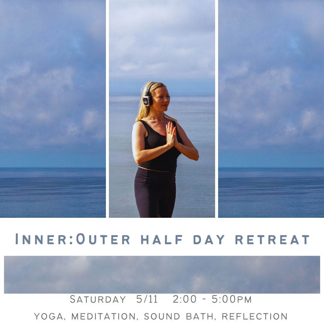 Woman practicing yoga outdoors by the water, wearing headphones, with hands in prayer position, facing the ocean, sky cloudy.