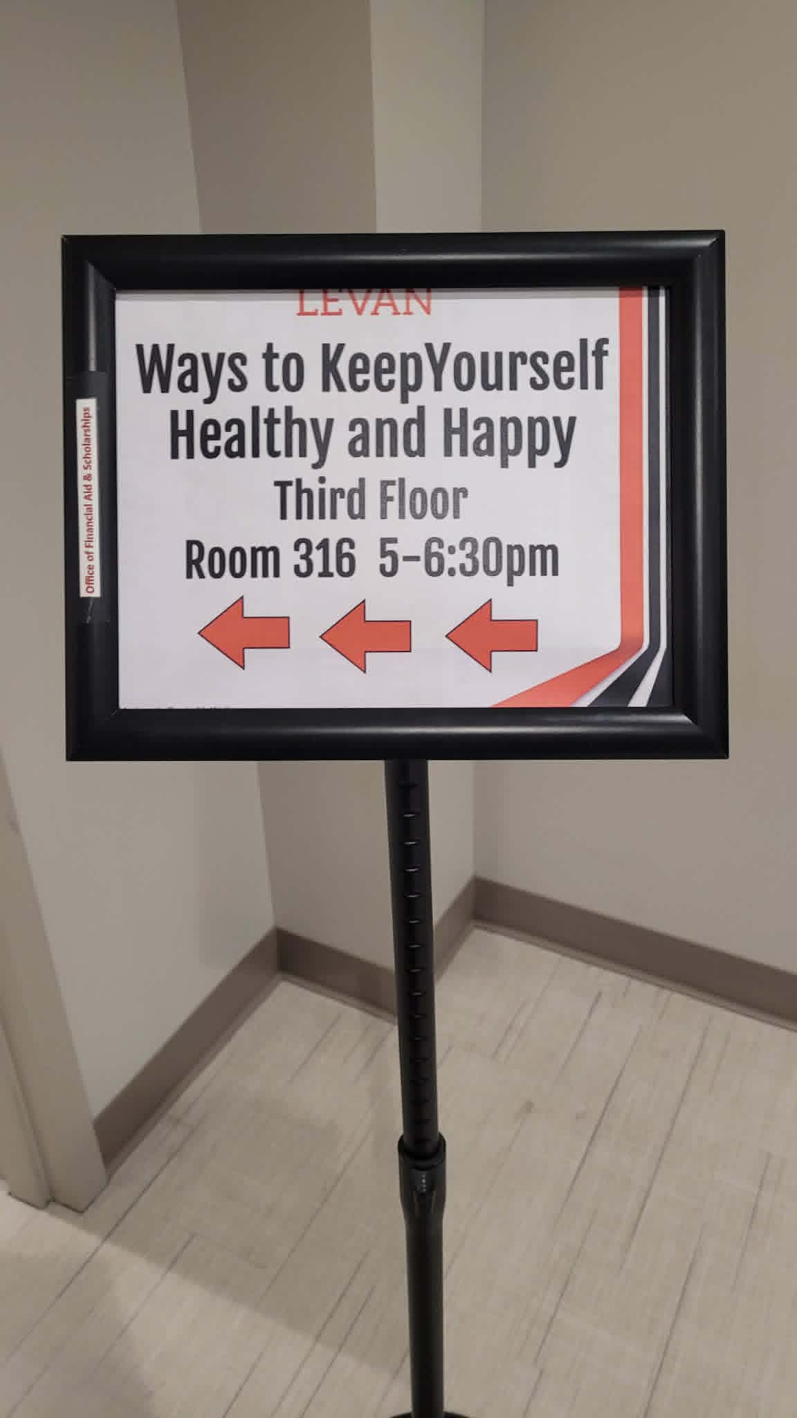 Sign with directions to a health and happiness event on the third floor, with arrows pointing left.