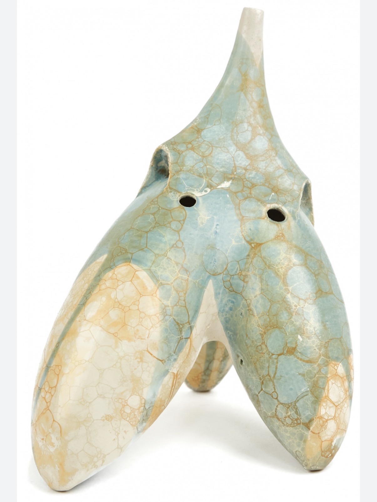 Ceramic sculpture with three legs and a tall, pointed top, painted in pastel blue, beige, and cream colors.