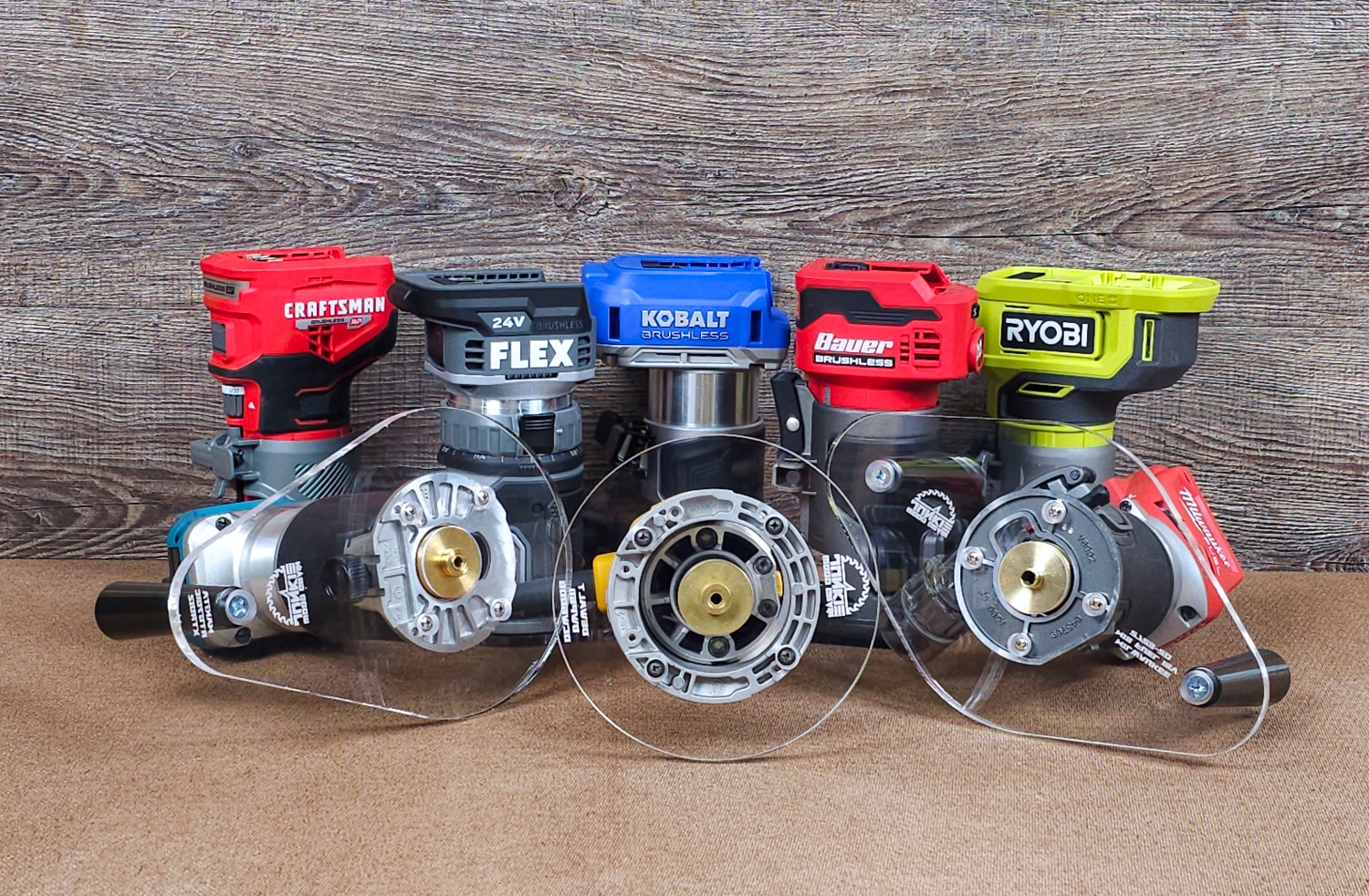 Four power tool batteries connected to a transparent plastic panel, with a wooden background and surface.
