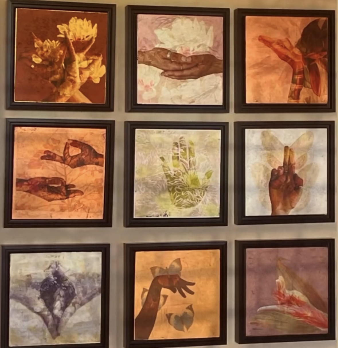 Six framed artworks of hands and flowers arranged in a grid on a wall, with warm tones and abstract styles.