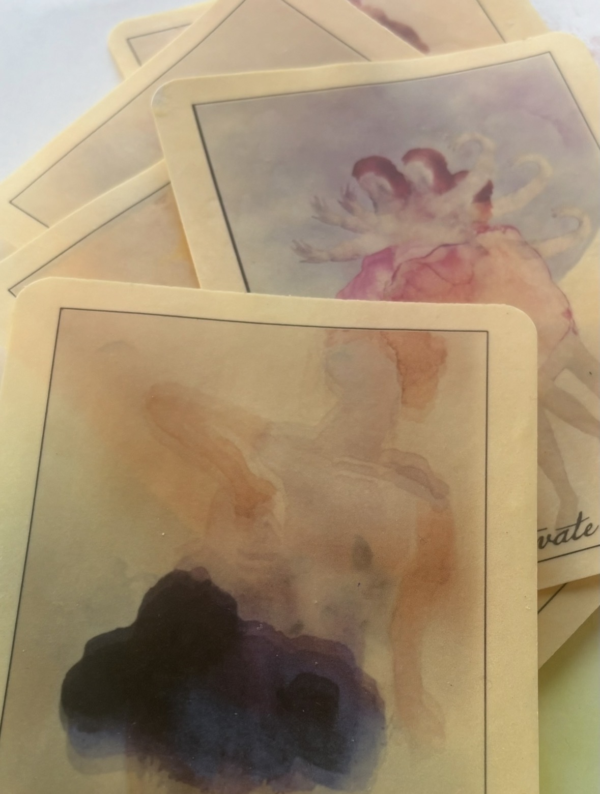 Multiple watercolor paintings with abstract shapes and soft colors, overlapping each other.