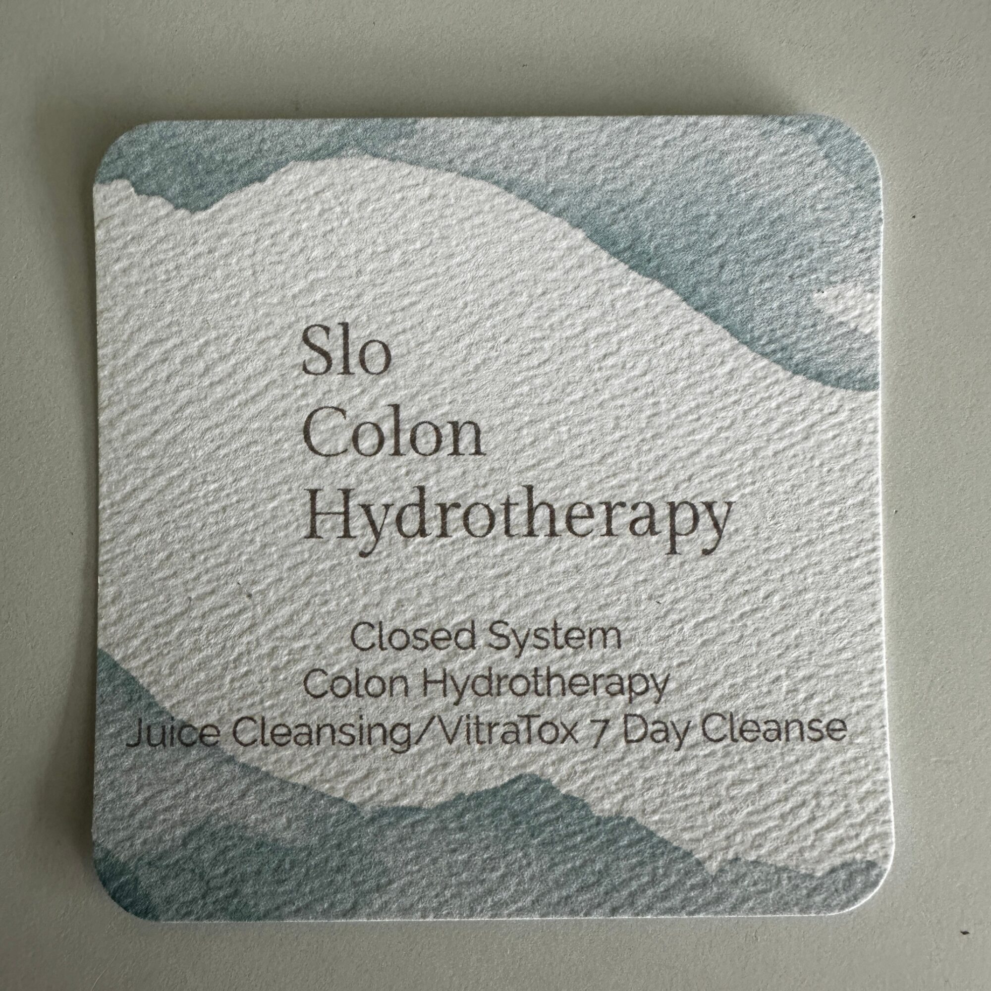 Square card with textured background and text about colon hydrotherapy and cleansing, with rounded corners.