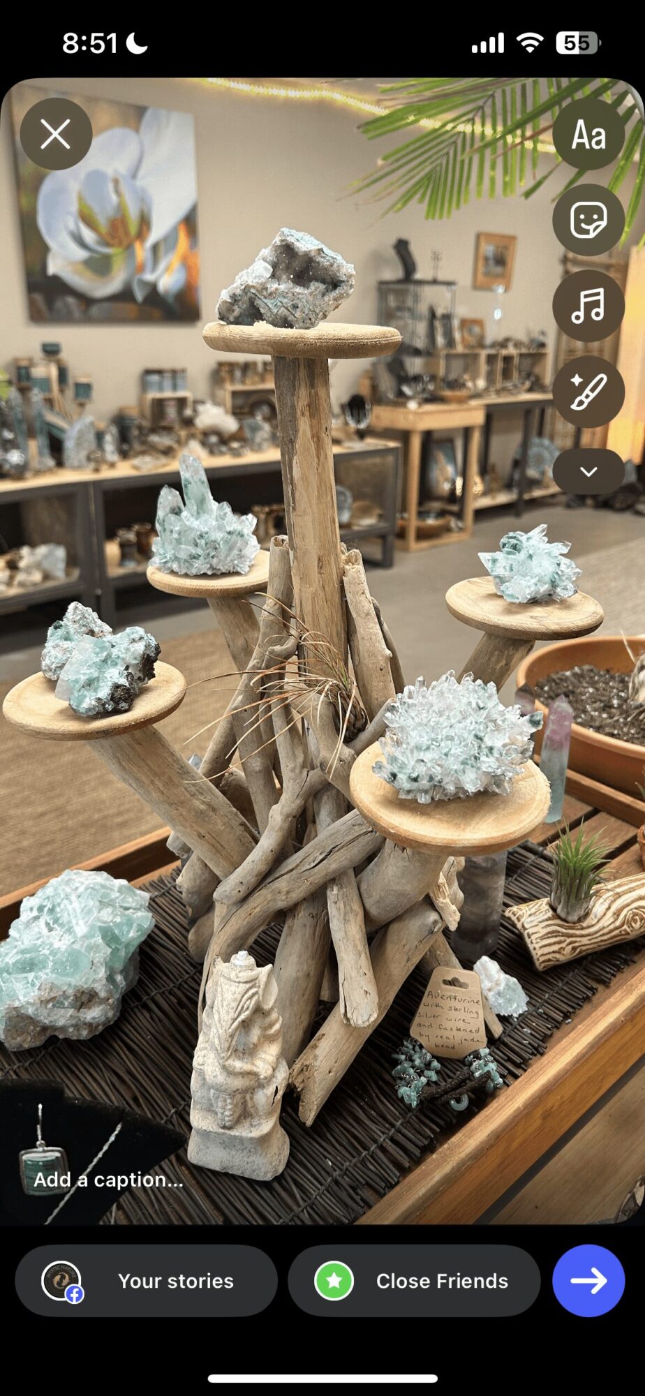 Decorative display with driftwood, blue mineral clusters, and wooden platforms in a room with artwork and furniture.