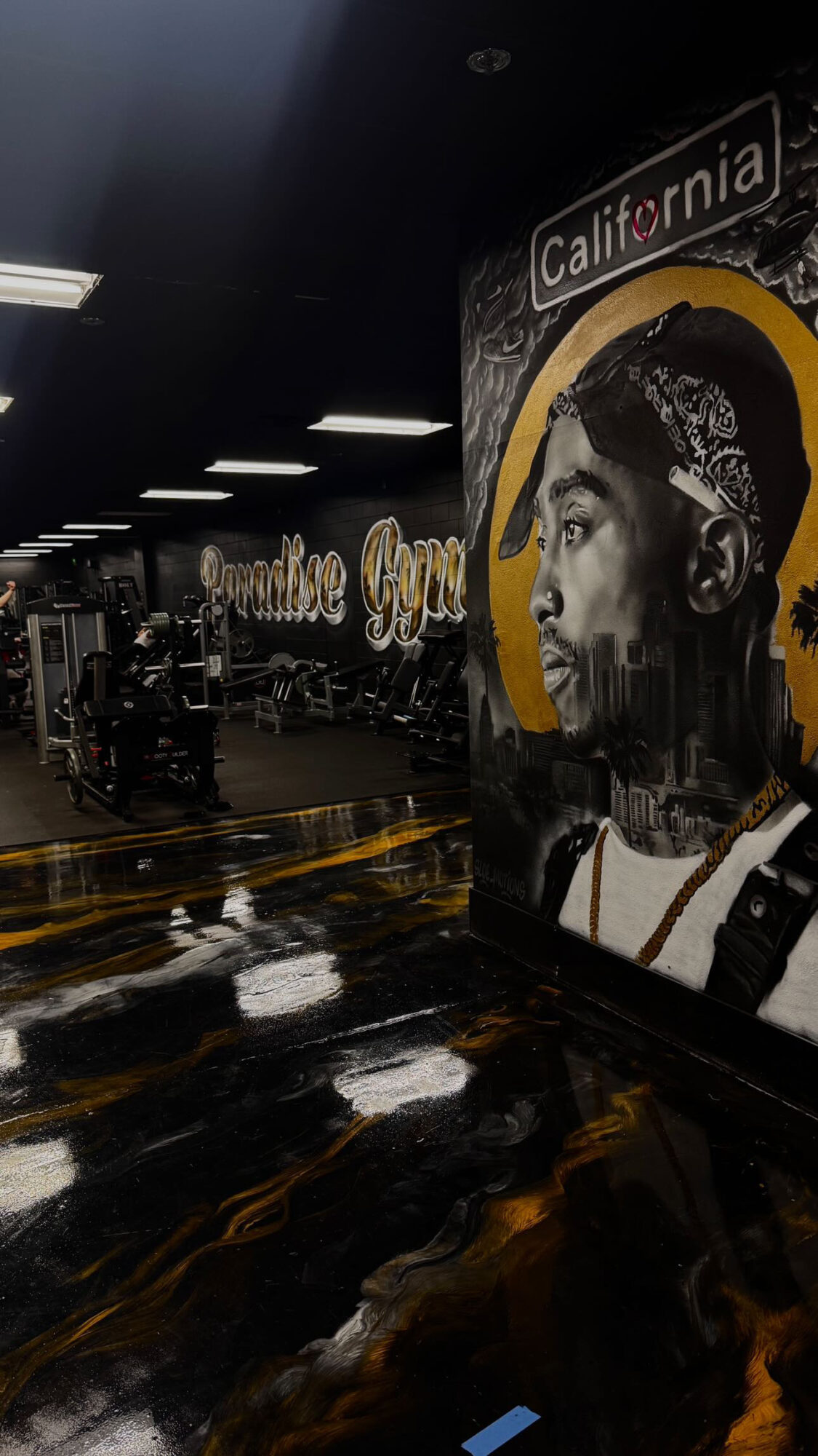 Indoor space with a mural of a person wearing a bandana and headphones, and the word 'California' at the top.