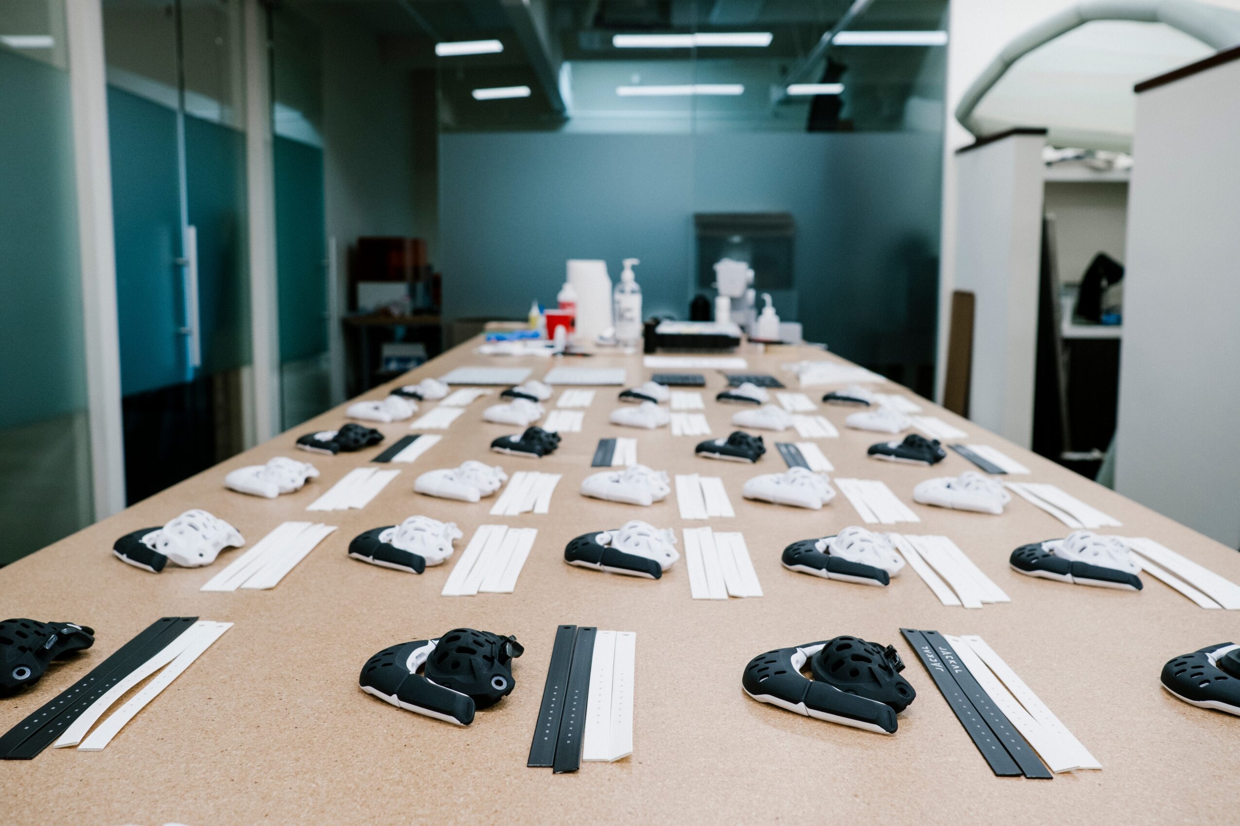 Conference room with a long table set with remote controls, notepads, and pens, in a modern office environment.