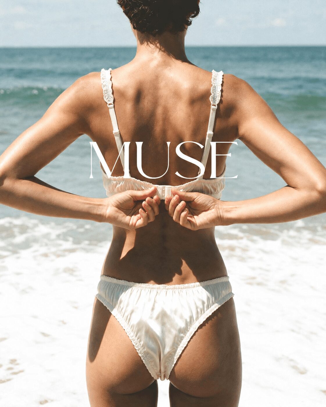 Woman standing on beach holding a shell behind her back, facing the ocean, with the word 'MUSE' overlaid.