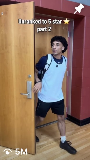 Young person standing in doorway, wearing a light blue shirt, black shorts, and a backpack, looking to the side.