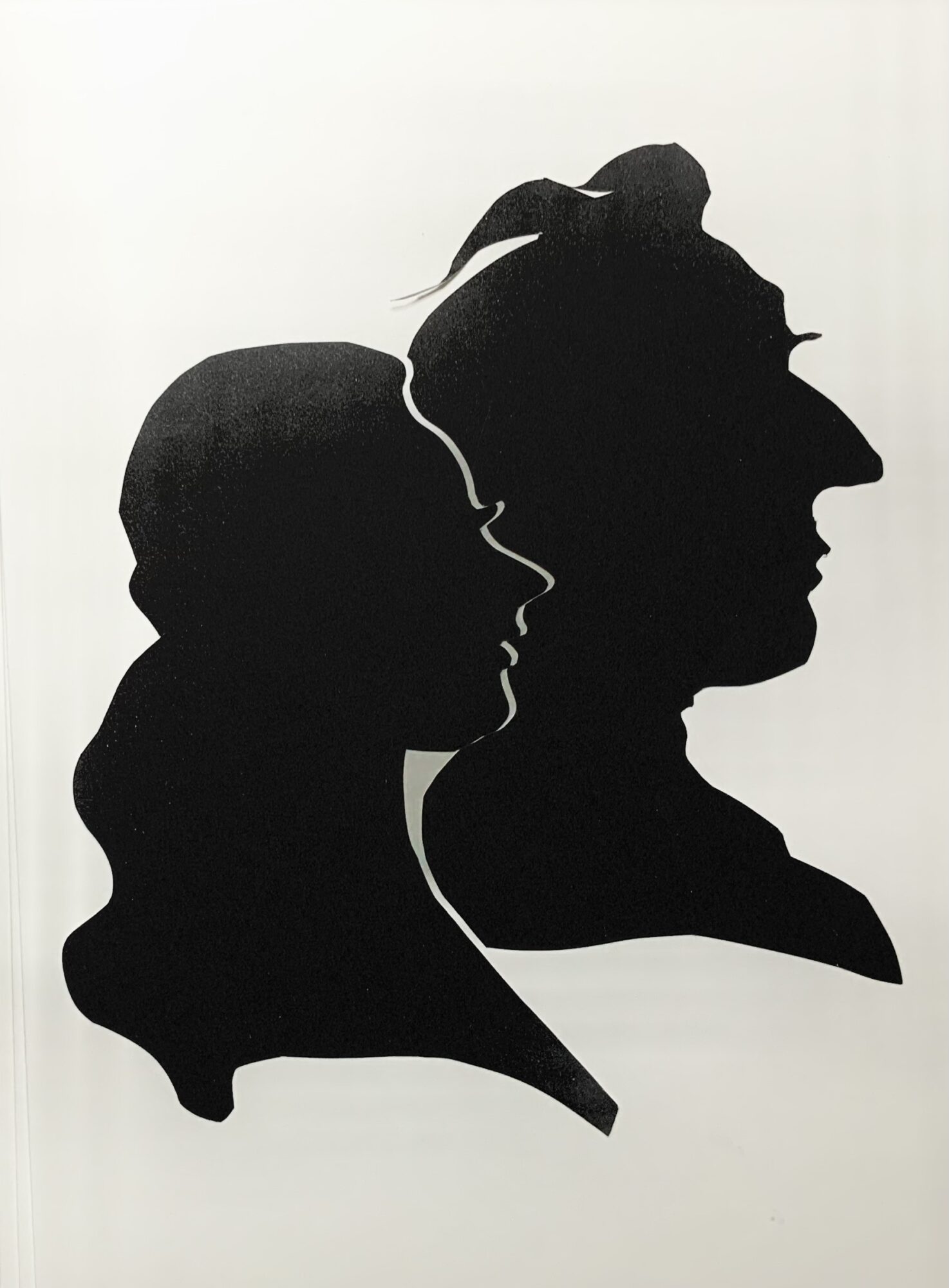 Silhouettes of a woman and a child in profile, facing right, with the woman's hair in a bun, against a white background.