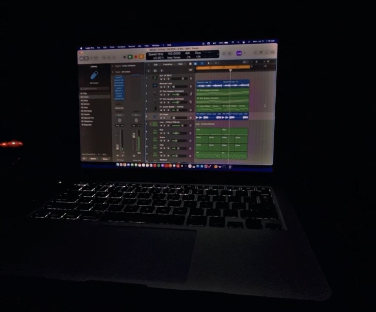 Laptop screen displaying music production software in a dark environment.