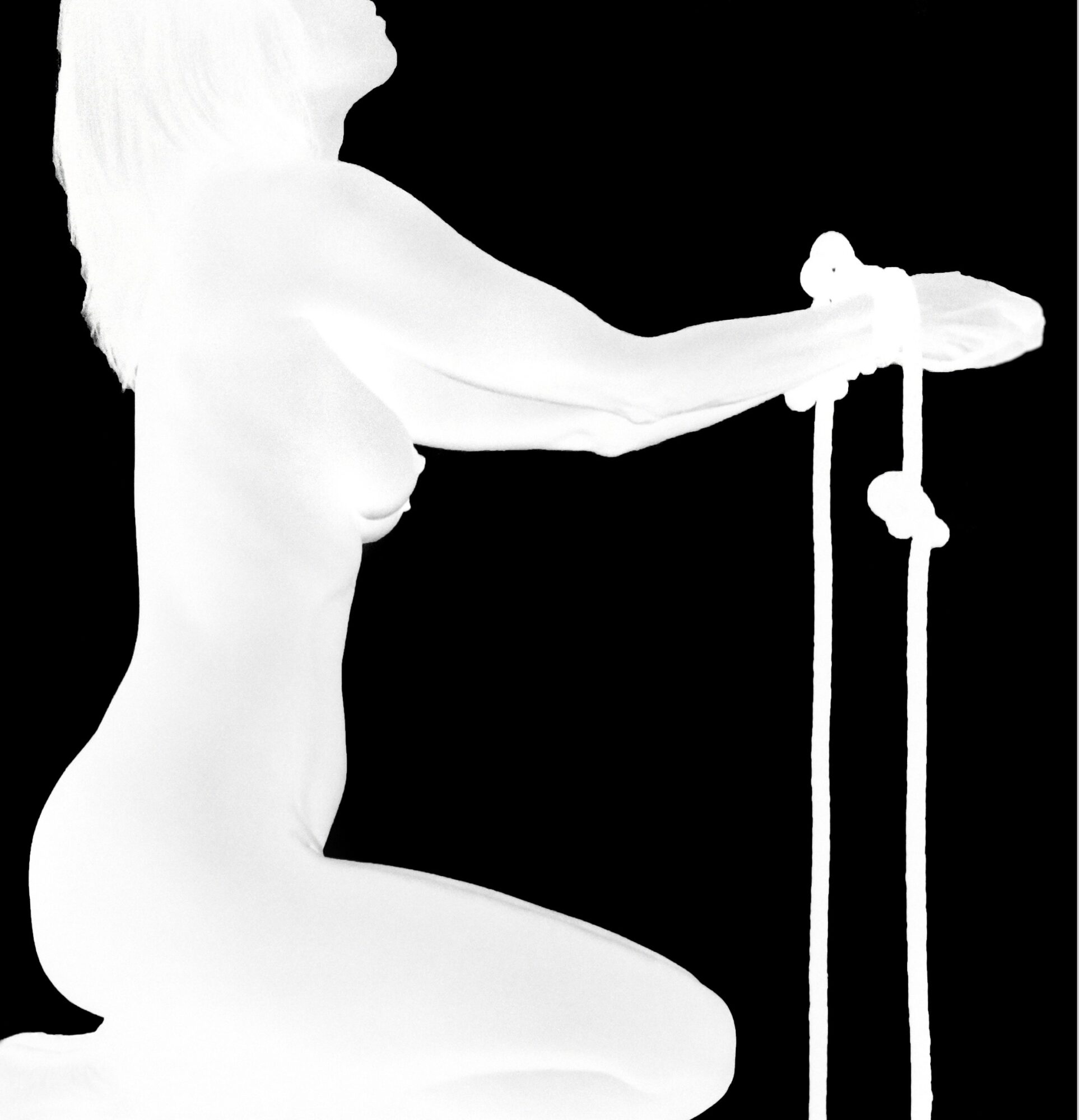 Silhouette of a person kneeling and holding a sword with both hands against a black background.