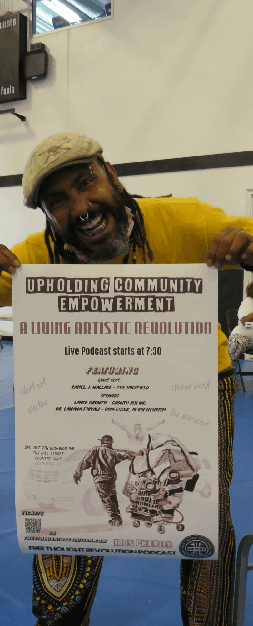 Person holding a poster with text and illustrations, wearing a yellow shirt and beige cap, smiling.