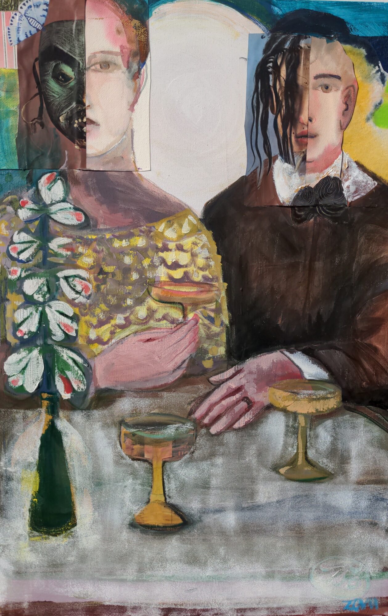 Two women sit at a table with a flower arrangement and glasses, one with short hair and the other with dreadlocks.