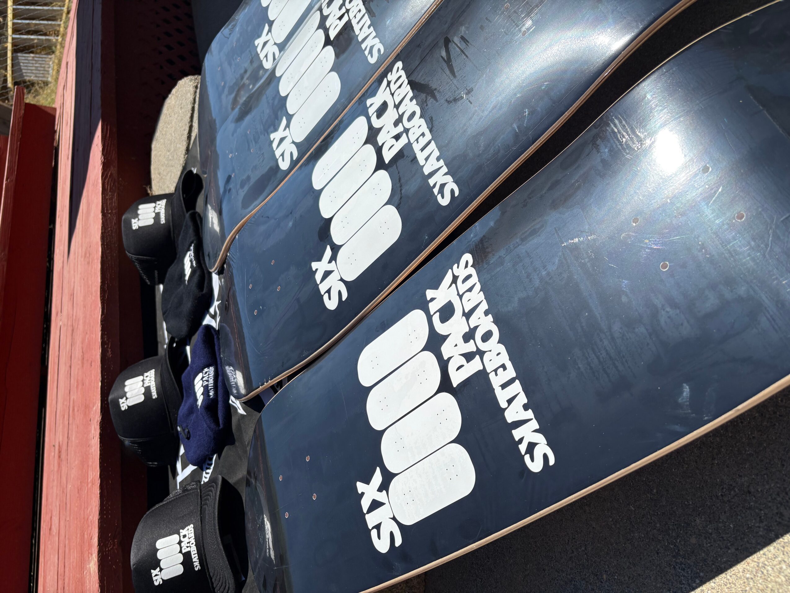 Three black inflatable boats with white logos and text, tied together on a dock, viewed from the side.