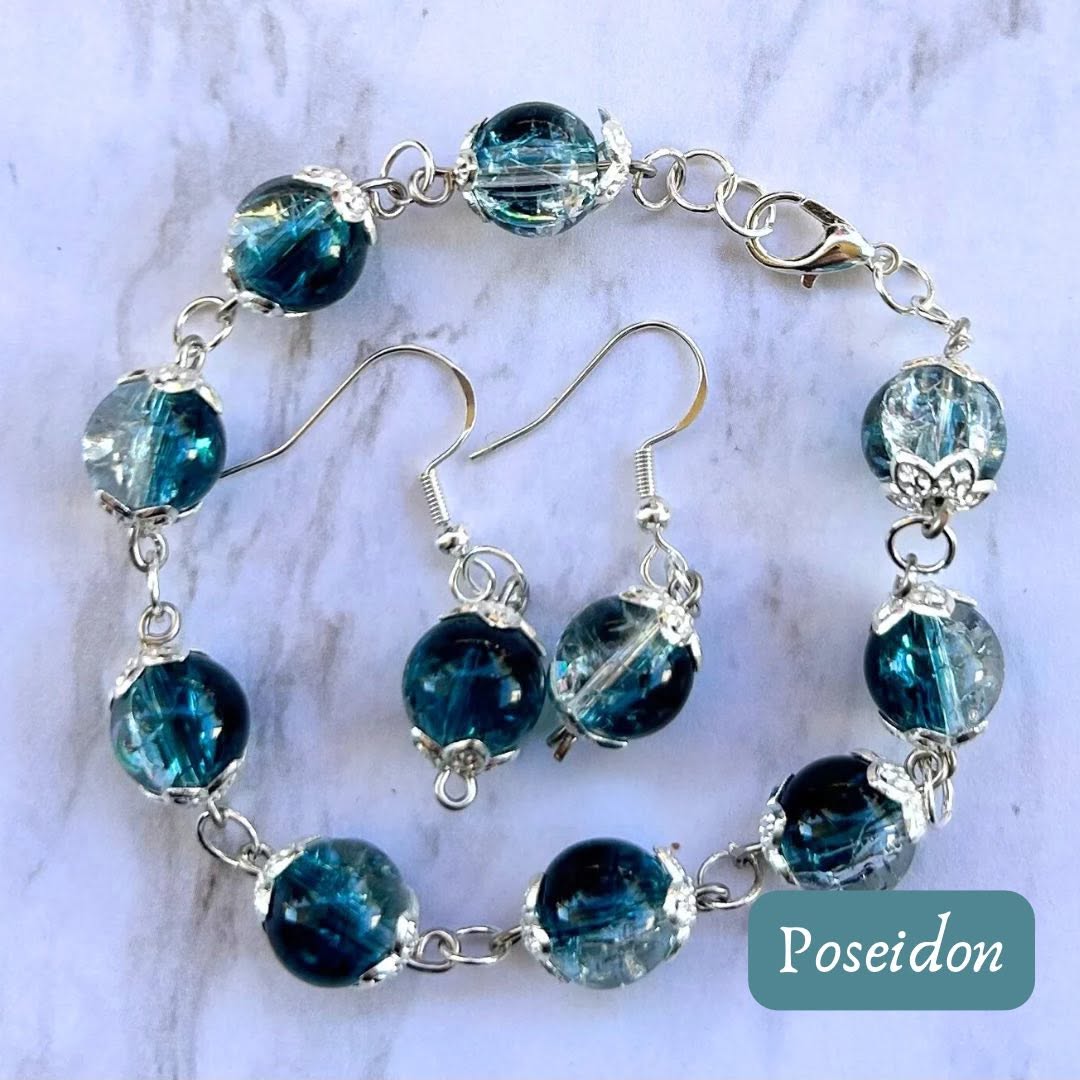 Set of blue glass bead jewelry including a bracelet and earrings on a marble surface.
