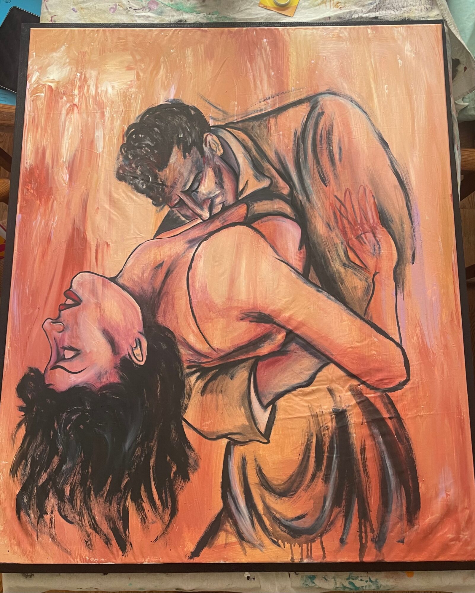 Two people embrace, one with long dark hair and the other with short dark hair, against a warm orange background.