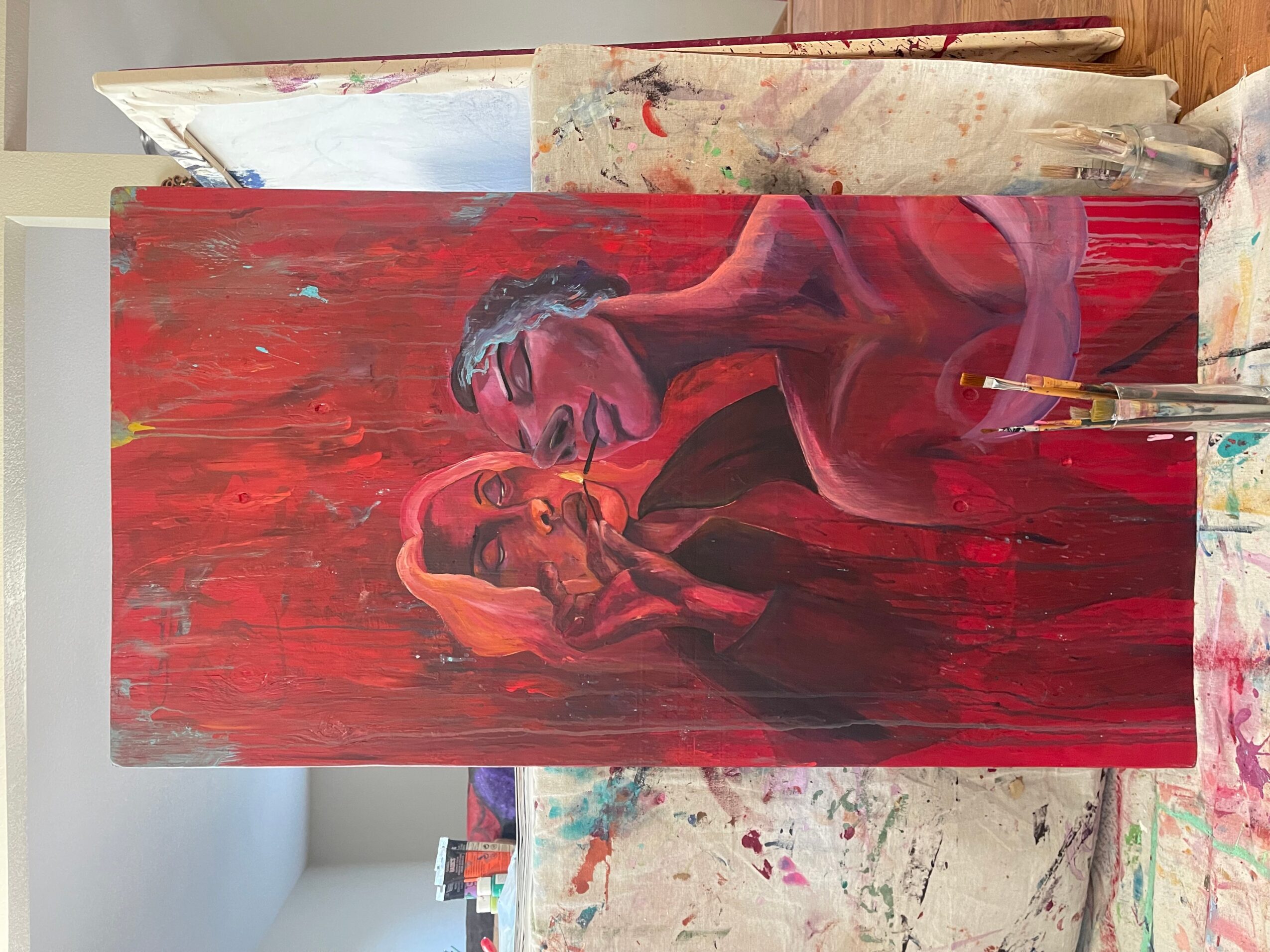 Painting of two people embracing, with red background and expressive brushstrokes.