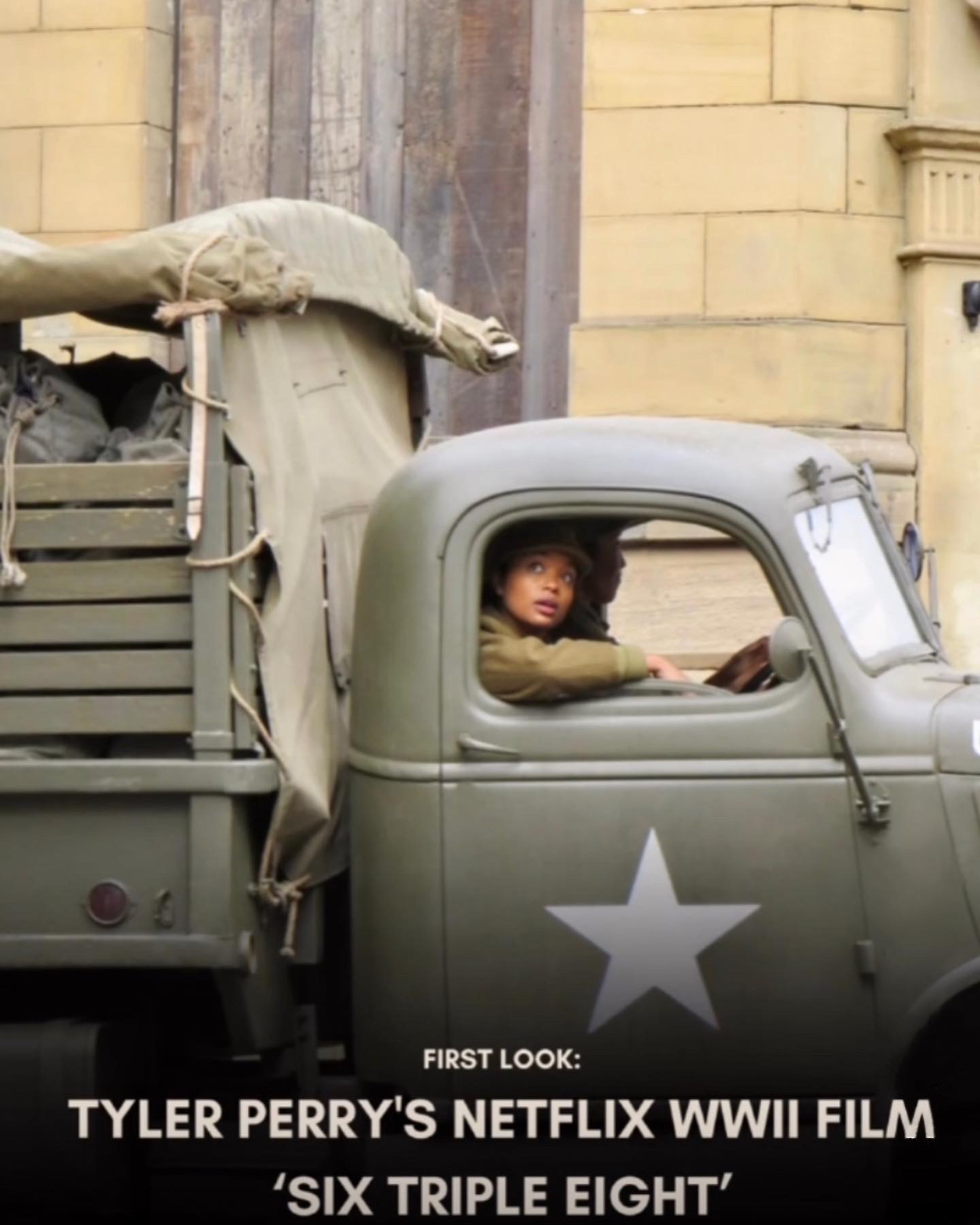 Child sitting in the driver's seat of a vintage military truck with a star on the door, looking out the window.