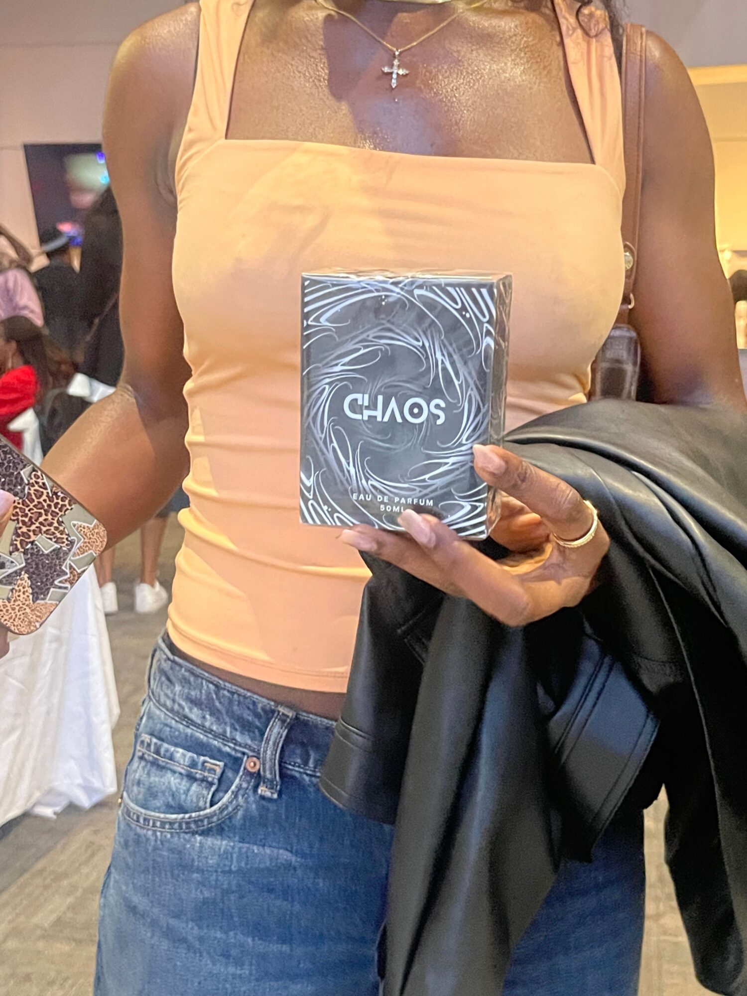 Person holding a book titled 'CLOWNS' in front of their chest, wearing a yellow top and blue jeans, with a leather jacket.