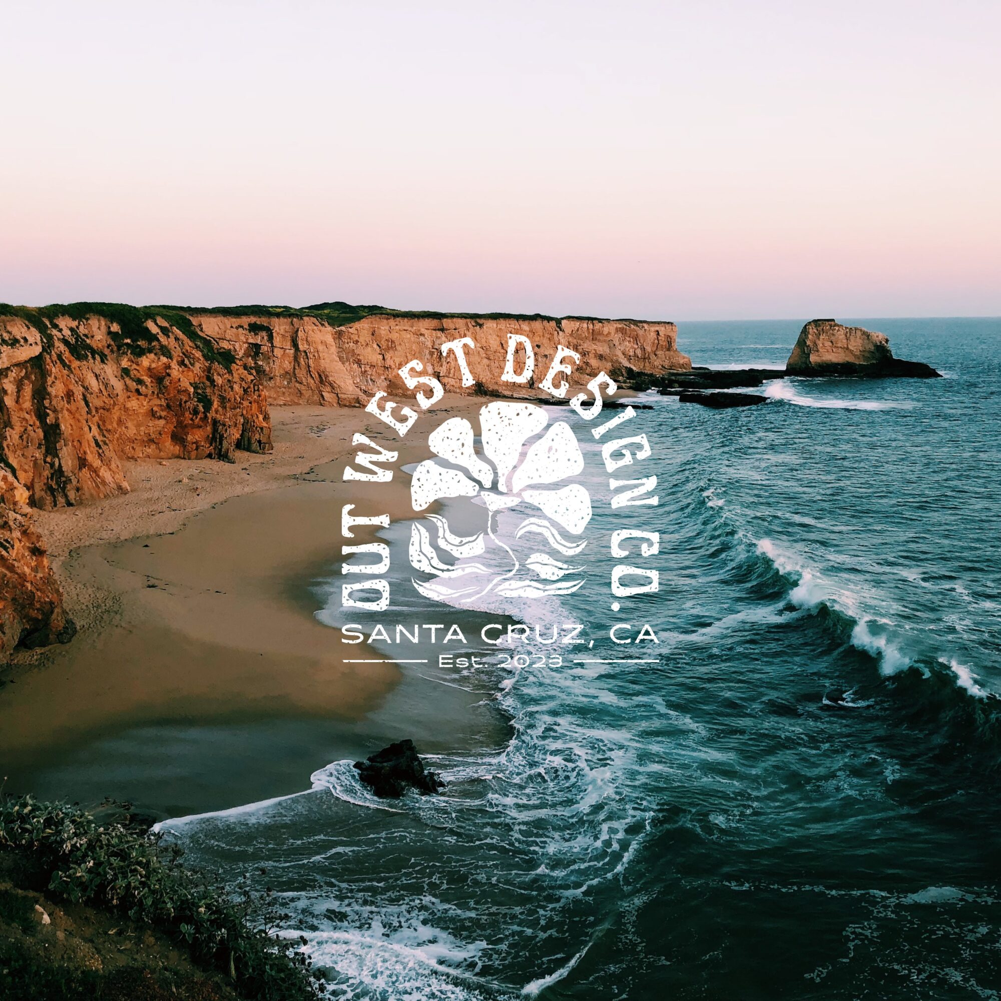 Cliffside beach with waves crashing, rocky formations, and a pastel sky at sunset, with a logo overlay reading Out West Design Co., Santa Cruz, CA.