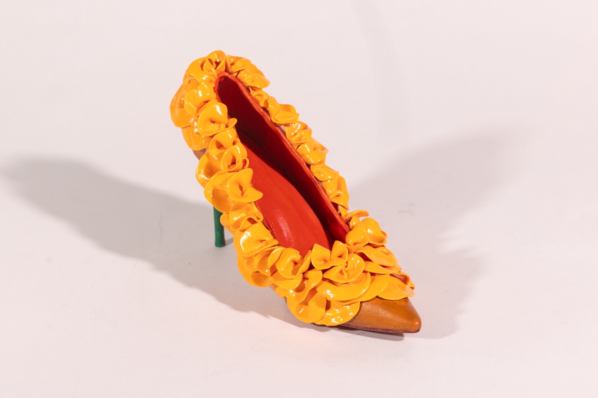 Toy crocodile with yellow flowers around its open mouth, on a white background.