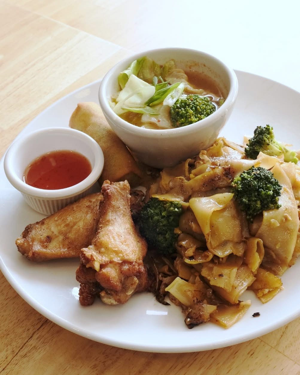 Plate with fried chicken, broccoli, and a bowl of soup with vegetables, plus a small dish of sauce.